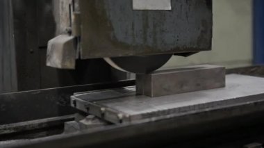 Sallanan sanayi öğütme makinesi çelik işyerinde çalışıyor. Değirmen taşının her geçişinde kıvılcım saçıyor. Statik kamera, kapat.