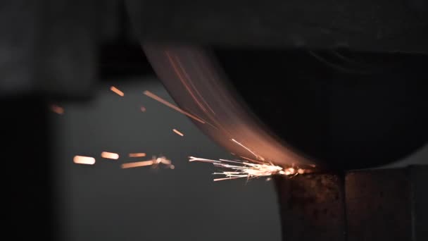Houpačka průmyslové brusky pracuje na ocelovém obrobku odlévání jiskry na každém průchodu brusného kamene - statická kamera, zblízka — Stock video