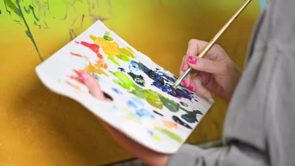 Žena Umělec míchá barvy na paletě, malíř ve studiu, tvůrce dělá umělecké dílo. — Stock video