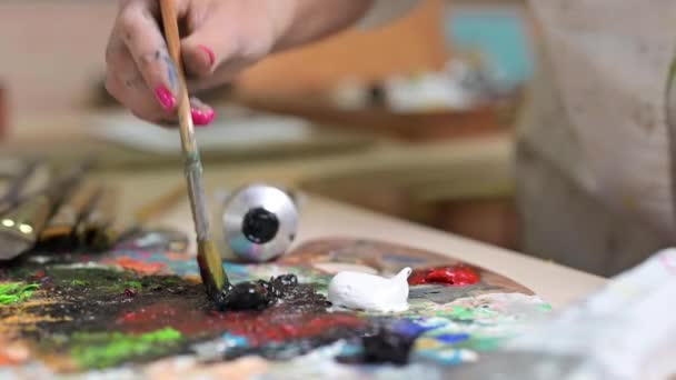 創造的な女性画家はパレットに油絵具のパレットを混合します。クローズアップビュー — ストック動画