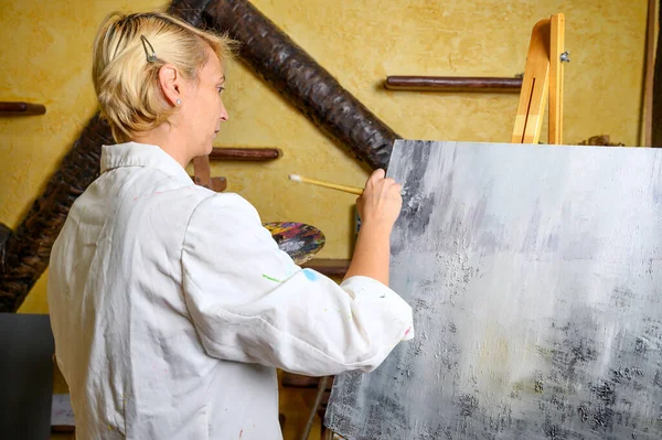 Γυναίκα έχει τη διασκέδαση ζωγραφική στην τάξη των τεχνών — Φωτογραφία Αρχείου