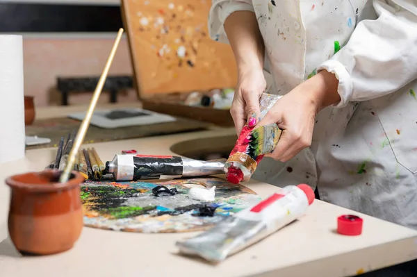 O pintor feminino criativo mistura a paleta de pinturas a óleo na paleta. Vista de perto — Fotografia de Stock