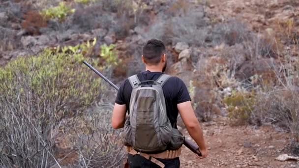 Onherkenbare Hunter die stilletjes op jacht gaat tijdens het jachtseizoen. Hunter in camouflage kleding met jachtgeweer. — Stockvideo