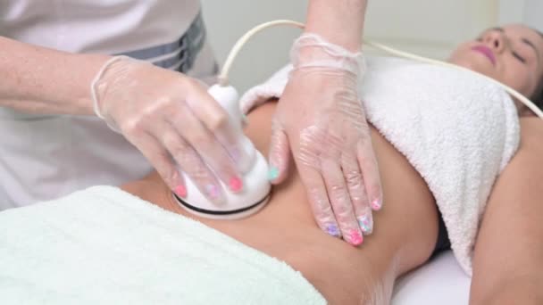 Mujer recibiendo tratamiento de cavitación por ultrasonido por cosmetólogo. cliente femenino disfrutando del procedimiento anti-celulitis en el salón de belleza. — Vídeo de stock