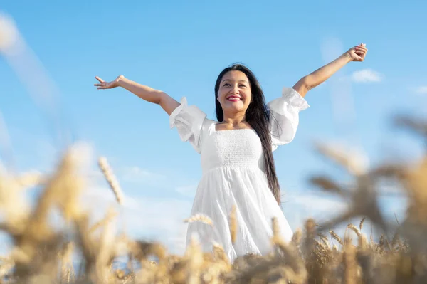 Portret szczęśliwej młodej kobiety w białej sukience, na polu pszenicy. Koncepcja stylu życia i szczęścia. Kobieta z otwartymi ramionami . — Zdjęcie stockowe