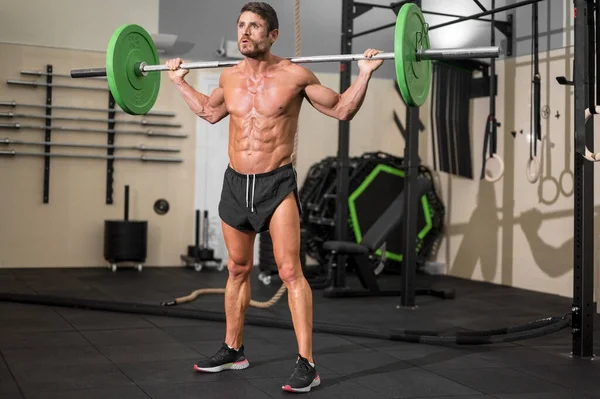 Fit man bodybuilder doing barbell squats at gym. — Stock Photo, Image