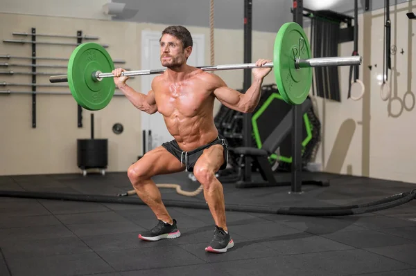 Fit man bodybuilder doing barbell squats at gym. — Stock Photo, Image