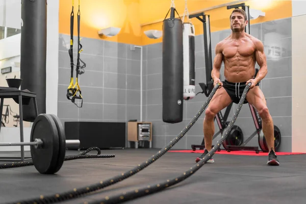 Muscular powerful man working out with rope in functional training fitness gym. — Stock Photo, Image