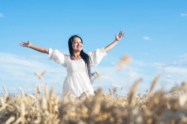 Retrato de una joven feliz con un vestido blanco, en un campo de trigo. Concepto de estilo de vida y felicidad. Mujer con los brazos abiertos . —  Fotos de Stock