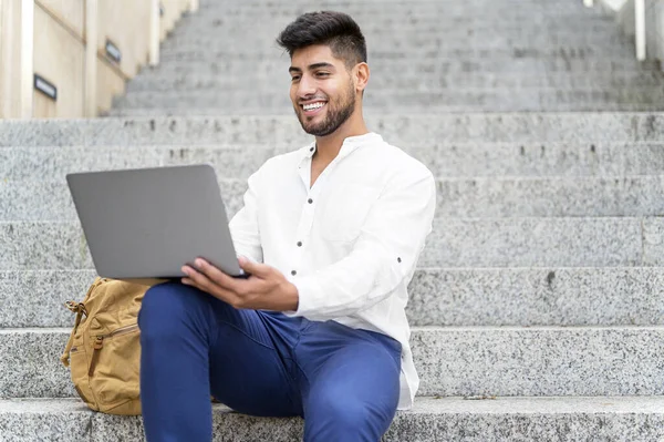 Handsome young man working with laptop on stairs — Stock Photo, Image