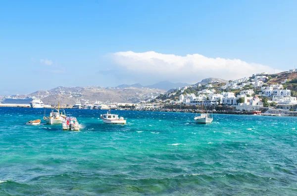 Små fiskebåtar och traditionella hus i bakgrunden i den berömda ön mykonos. — Stockfoto