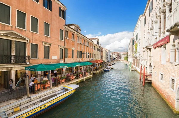 Güneşli bir günde, restoranlar, turistler, oteller ve küçük bir köprü üzerinde canal de dahil olmak üzere, tipik Venedik kanalına. — Stok fotoğraf