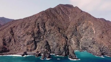 Vallehermoso 'nun engebeli kıyı şeridi, La Gomera, Kanarya Adaları. Sahne dramatik volkanik kayalıkları, derin mavi Atlantik sularını ve okyanusla buluşan yemyeşil tepeleri gösteriyor. Bu uzak ada manzarasının vahşi güzelliğini yakalıyor.. 