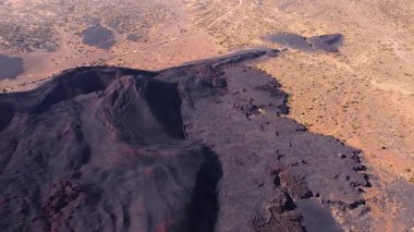İspanya 'nın Tenerife kenti yakınlarındaki Fasnia' nın volkanik manzarasının hava aracı görüntüsü engebeli lav oluşumlarını, koyu kül eğimlerini ve dramatik jeolojik araziyi gösteriyor. Yüksek kalite 4k görüntü