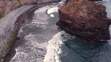 Tenerife 'deki Los Roques plajının havadan görünüşü, engebeli volkanik kayalar, çarpan dalgalar ve San Juan de la Rambla yakınlarında vahşi bir kıyı şeridi. Yüksek kalite 4k görüntü