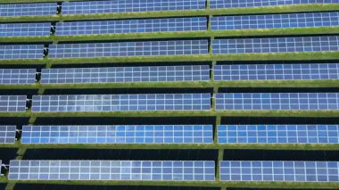 Temiz yenilenebilir enerji üreten, sürdürülebilir enerji üreten, düşük karbonlu bir gelecek için sürdürülebilir enerji üretimi, yeşil teknoloji ve modern altyapı sunan büyük bir güneş paneli çiftliğinin havadan görünüşü. 