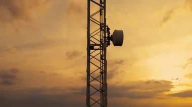 Telekomünikasyon kulesinin manzaralı günbatımı sırasında hava manzarası. Hücresel mobil sinyalleri iletmek için tasarlandı. Yüksek hız 4G ve modern 5G trafik ağı hizmeti sağlıyor.. 