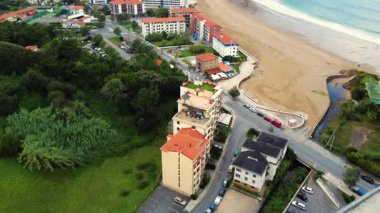 Kuzey İspanya 'daki Bask Bölgesi' nde Bakio plajı ve kıyı kasabasının havadan görüntüsü. Kumlu sahil şeridi, deniz kenarı ve Cantabrian Denizi boyunca yeşil tepeler, insansız hava aracı tarafından ele geçirildi. Yüksek kalite 4k görüntü