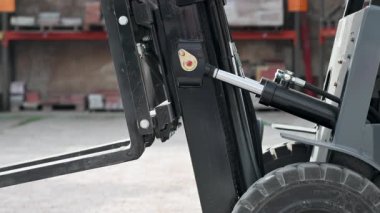 Forklift indirme çatalları depoda kapanır, endüstriyel kaldırma ekipmanları çalışır. Yüksek kalite 4k görüntü