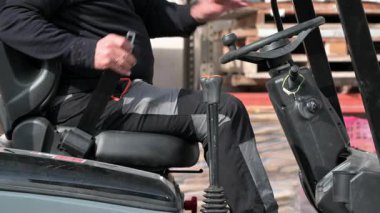 Forklift operatörü iş yerindeki güvenlik prosedüründen önce emniyet kemerini bağlıyor. Yüksek kalite 4k görüntü