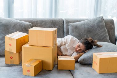 Güzel Asyalı kadınlar kanepelerde uyurlar. Küçük işletmeleri olan bir sürü paket kutuyla. Müşterilere internet üzerinden satış yaparlar..