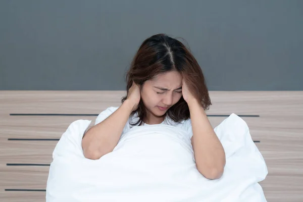 若いですアジアの女性はベッドの上で彼女の頭を保持して横たわっている強力な頭痛多分ベッドの上で午前中に偏頭痛 — ストック写真