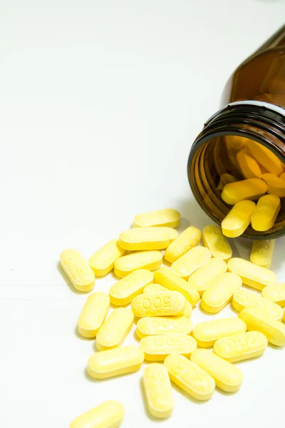 Żółte tabletki na białym tle — Zdjęcie stockowe