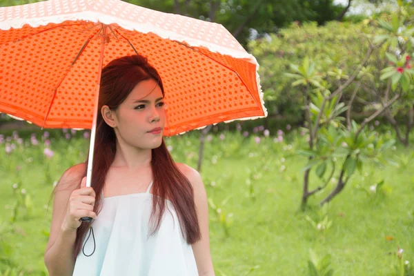 Молодые женщины и оранжевый зонтик — стоковое фото