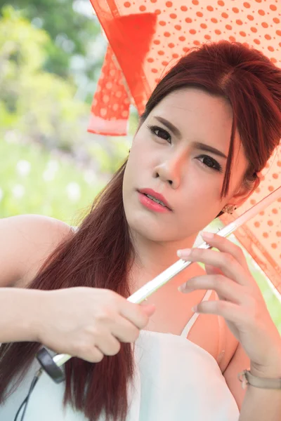 Mujeres jóvenes y paraguas naranja — Foto de Stock