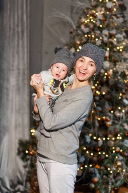 Noel 'de şapkalar ve süveterler içinde gülen anne ve küçük kız. dikey resim