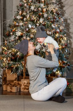 Yılbaşı arabasında gülen anne ve kız bebek Noel ağacı. Yılbaşı fotoğraf çekimi