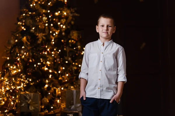 Felice Ragazzo Camicia Bianca Natale Guarda Fotocamera Uno Sfondo Scuro — Foto Stock