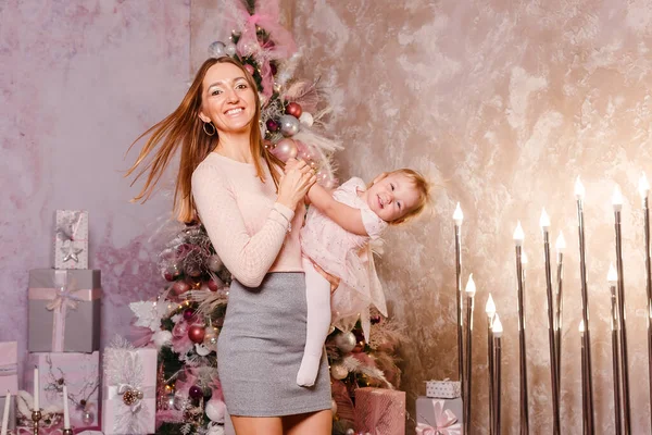 A happy smiling woman circles a baby girl for Christmas. family photo shoot
