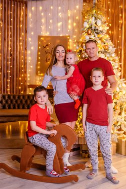 Beş kişilik mutlu bir aile, bir stüdyoda altın rengi bir fotoğraf çekiminde. Noel için insanlar.