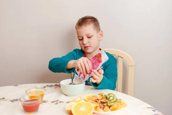 Девятилетний Мальчик Пижаме Сидит Столом Ест Овсянку Фруктами Здоровый Завтрак — стоковое фото