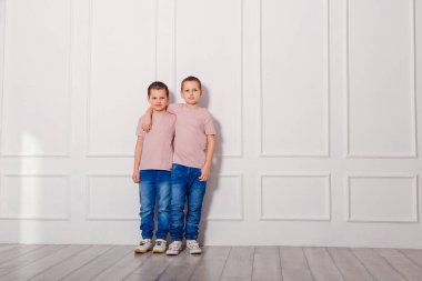 İki çocuk içeride fotoğraf çekimi için poz veriyor.