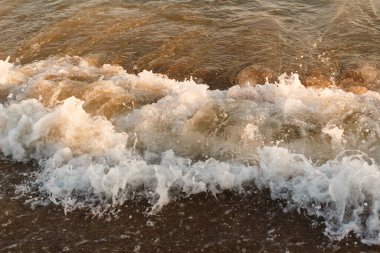 Yazın Türkiye 'de plajda köpüren beyaz dalgalar.