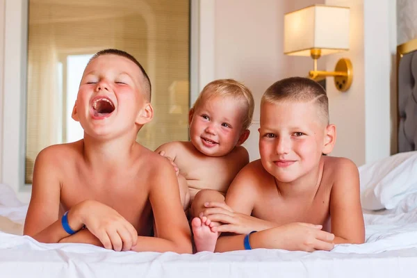 Трое Веселых Смеющихся Загорелых Красивых Детей Лежат Кровати Номере Отеля — стоковое фото