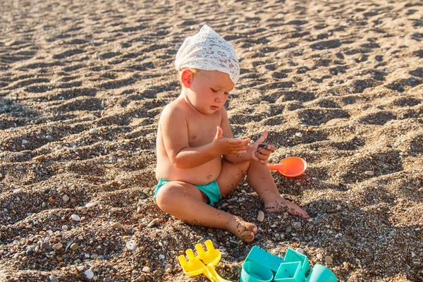 Een Schattig Klein Meisje Een Zwembroek Zit Het Strand Speelt — Stockfoto