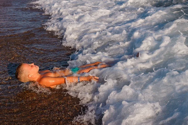 Tanned Nine Year Old Boy Lies Beach Waves — Stock Photo, Image