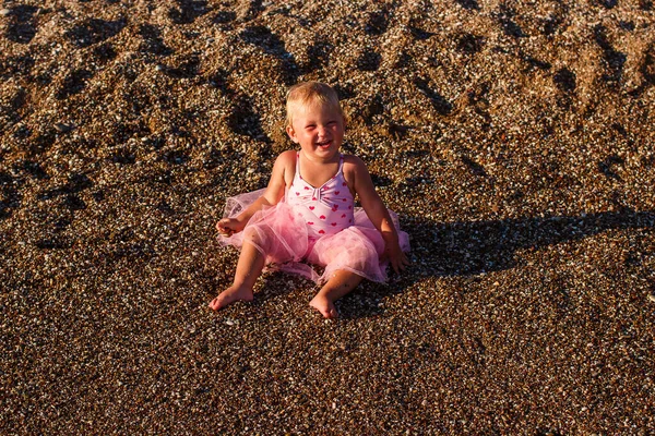 Смеющаяся Загорелая Годовалая Девочка Розовом Купальнике Сидит Пляже — стоковое фото