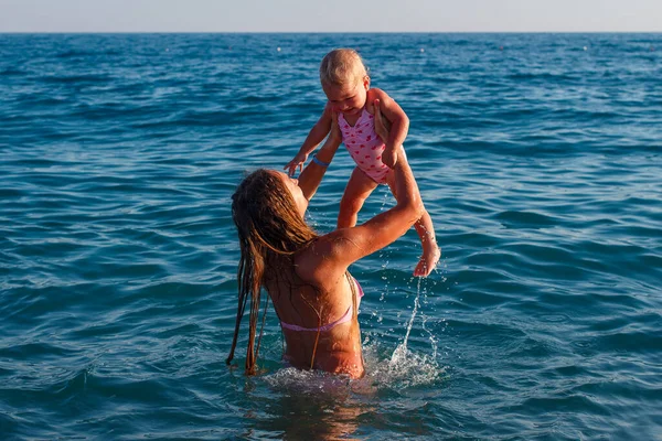 Молодая Женщина Окунает Годовалую Девочку Розовый Купальник Море — стоковое фото