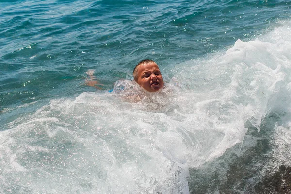 短髪の9歳の男の子が海で泳いで夏に波と遊ぶ — ストック写真