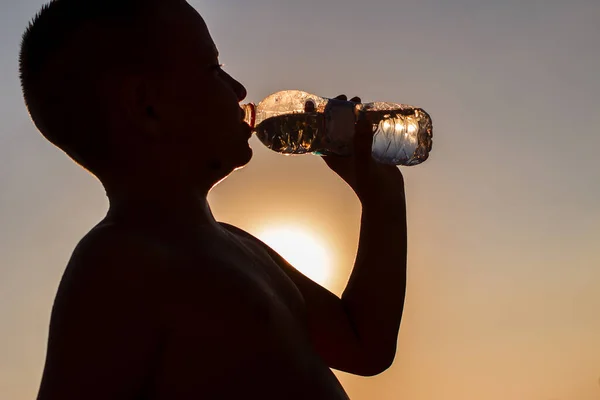 Short Haired Boy Drinks Water Bottle Counter Light Silhouette — Stock Photo, Image