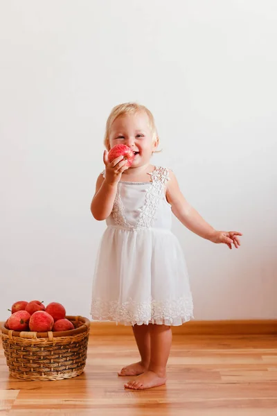 Rubia Niña Vestido Blanco Muerde Grandes Manzanas Rojas Contra Fondo —  Fotos de Stock