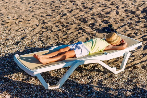 Niño Bronceado Yace Cubierto Con Sombrero Una Tumbona Arena —  Fotos de Stock