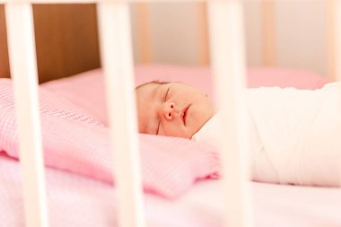 Newborn baby sleeps in crib close
