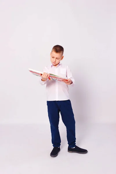 Desetiletý Chlapec Školní Uniformě Knihami Rukou Stojí Plné Výšce Bílém — Stock fotografie