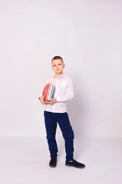 Мальчик Белой Рубашке Держит Стопку Книг Белом Фоне — стоковое фото