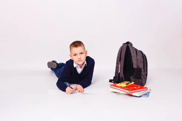 Menino Dez Anos Uniforme Azul Escola Jaz Sobre Fundo Branco — Fotografia de Stock